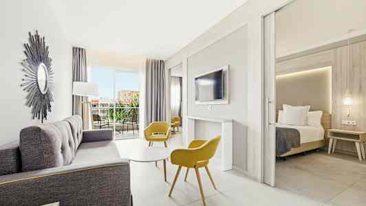 Lyst og moderne hotelværelse med siddeområde, soveværelse og altan. (AI-genereret tekst)