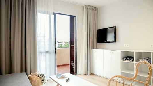 Moderne møbleret hotelværelse med åben dør til balkon. (AI-genereret tekst)