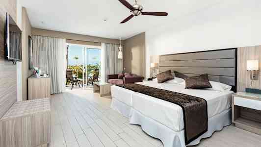 Moderne hotelværelse med dobbeltseng, siddegruppe og altan. (AI-genereret tekst)