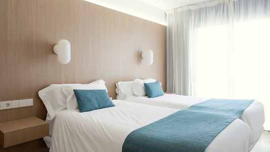 Værelse med to enkeltsenge og bløde blå detaljer. (AI-genereret tekst)