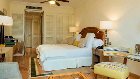 Hotelværelse med dobbeltseng, skrivebord og stol. (AI-genereret tekst)