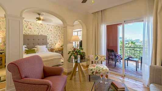 Et hotelværelse med siddegruppe, seng og altan. (AI-genereret tekst)