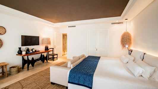 Et moderne hotelværelse med en stor seng og en siddegruppe, samt et TV og et bord med kaffemaskine. (AI-genereret tekst)