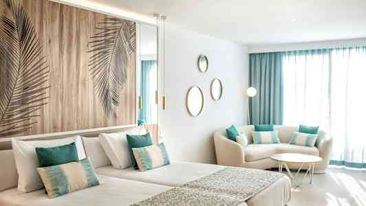 Et moderne hotelværelse med to enkeltsenge, siddeområde og dekorationer. (AI-genereret tekst)