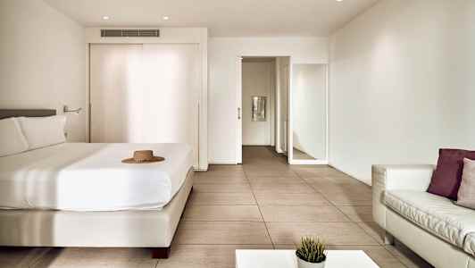 Et moderne hotelværelse med en seng, sofa og bord. (AI-genereret tekst)