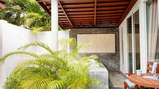 Terrasse med tag, bord og stole samt planter og moderne omgivelser. (AI-genereret tekst)