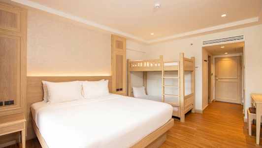 Hotelværelse med en dobbeltseng og en køjeseng. (AI-genereret tekst)