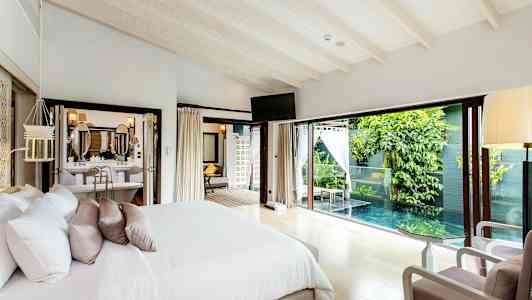 Soveværelse med dobbeltseng, hvor der er et vindue mod en privat pool og grønne omgivelser. (AI-genereret tekst)