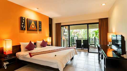 Et hotelværelse med en stor seng, orange vægge og en terrasse med stole udenfor. (AI-genereret tekst)