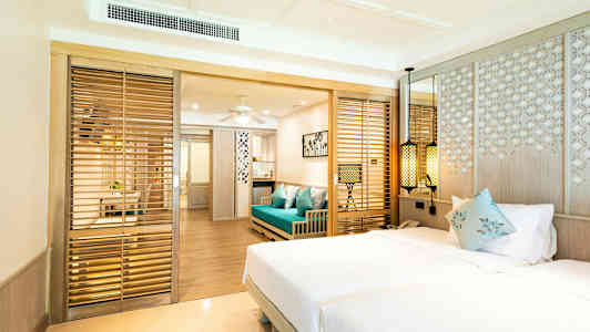 Hotelværelse med en dobbeltseng, blå sofa og trædetaljer. (AI-genereret tekst)