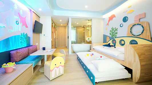 Et farverigt familieværelse med undervandstema, inklusive senge og legeområde. (AI-genereret tekst)