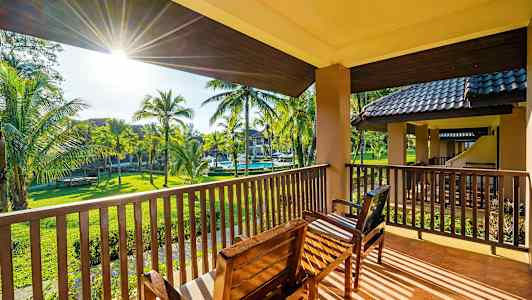 Udsigt fra en altan med siddepladser mod en have med palmer. (AI-genereret tekst)