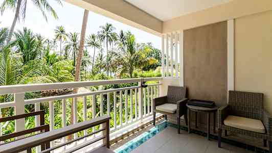 Billede af en altan med to siddepladser og bord, med udsigt til tropiske palmer. (AI-genereret tekst)