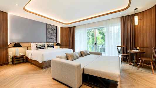 Værelse med en seng, sofa og spisebord. (AI-genereret tekst)