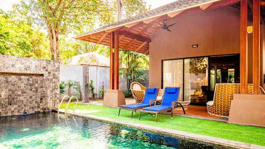 En villa med swimmingpool og liggestole på græsplænen. (AI-genereret tekst)