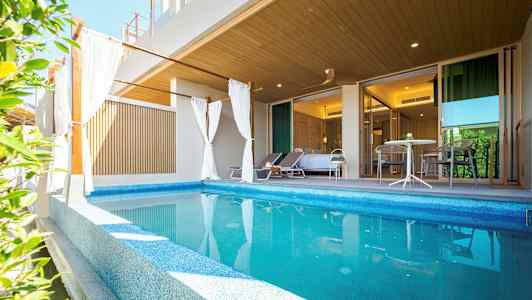 Privat pool med liggestole og siddeområde foran et soveværelse. (AI-genereret tekst)