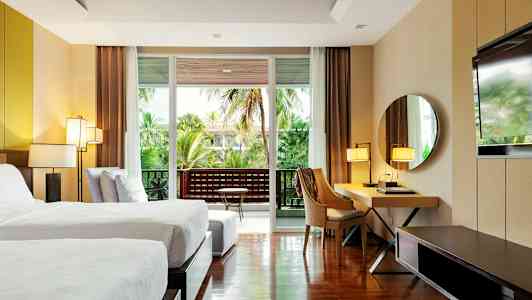 Moderne hotelværelse med to enkeltsenge, skrivebord, spejl og altan med grøn udsigt. (AI-genereret tekst)