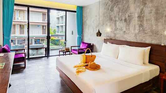 Hotelværelse med en redt dobbeltseng, vindue mod en bygning og dekoration på sengen. (AI-genereret tekst)