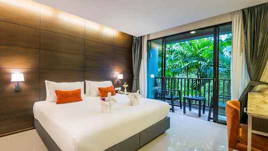 Et hotelværelse med en stor seng, dekorerede håndklædesvaner, en altan med udsigt over grønne omgivelser. (AI-genereret tekst)