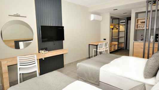 Et hotelværelse med to senge, en TV, et skrivebord og et lille køkken. (AI-genereret tekst)