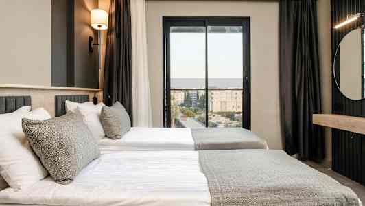 Værelse med to enkeltsenge, moderne indrettet med en neutral farvepalette. (AI-genereret tekst)