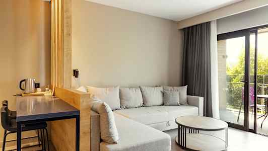 Moderne stue med grå sofa, træbord og store vinduer. (AI-genereret tekst)