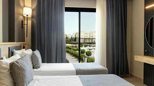 Hotelværelse med to enkeltsenge og vindue med udsigt til et poolområde. (AI-genereret tekst)