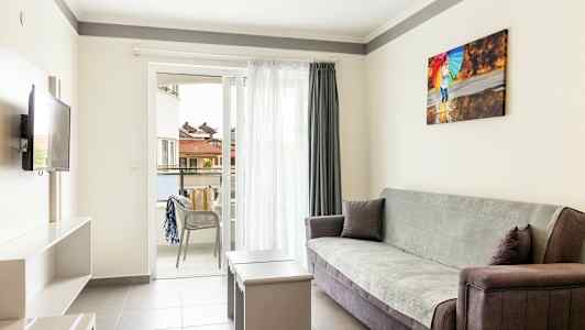 En lys stue med sofa, bord og åben altan. (AI-genereret tekst)