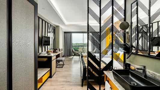 Billede af et moderne hotelværelse med skrivebord, stol og TV samt en separat soveafdeling. (AI-genereret tekst)