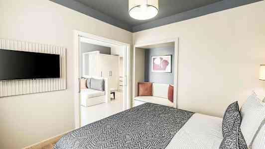 Moderne hotelværelse med seng, tekstiler og siddeområde. (AI-genereret tekst)