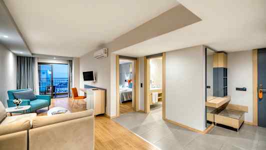 Billede af en moderne hotelsuite med siddeområde, soveværelse og badeværelse. (AI-genereret tekst)