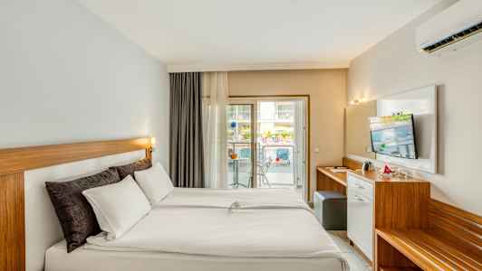 Hotelværelse med dobbeltseng og balkon. (AI-genereret tekst)