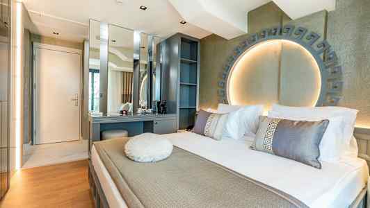 Moderne hotelværelse med seng, skrivebord og dekorativ belysning. (AI-genereret tekst)