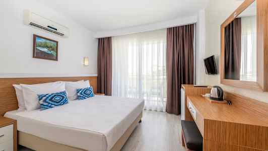 Et hotelværelse med dobbeltseng, skrivebord og altan. (AI-genereret tekst)