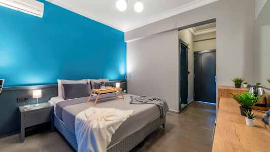 Soveværelse med en dobbeltseng, et bakkebord, blå væg og indretning. (AI-genereret tekst)