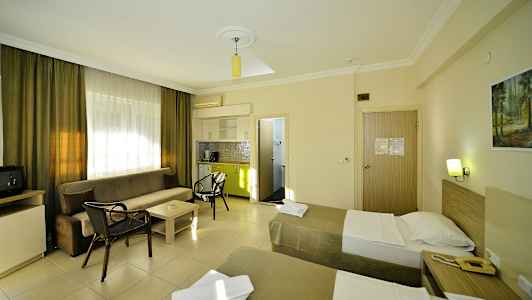 Et hotelværelse med to enkeltsenge, en sofa, et sofabord og et lille køkken. (AI-genereret tekst)