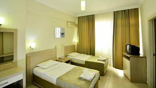 Hotelværelse med to enkeltsenge, skrivebord og tv. (AI-genereret tekst)