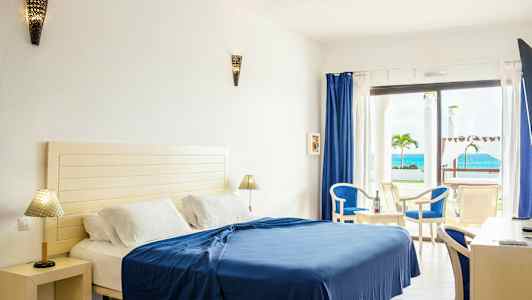 Hotelværelse med seng, møbler og havudsigt. (AI-genereret tekst)