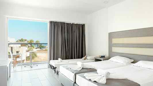 Et hotelværelse med to redte senge og en balkon med udsigt. (AI-genereret tekst)