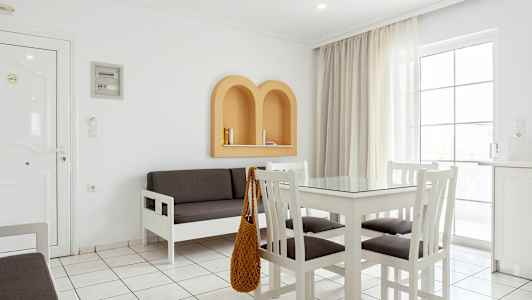 Et lyst interiør med hvide møbler, en grå sofa og beige detaljer på væggen. (AI-genereret tekst)