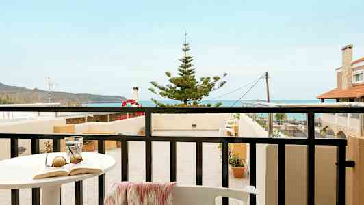 En balkon med udsigt over havet og nærliggende bygninger. (AI-genereret tekst)