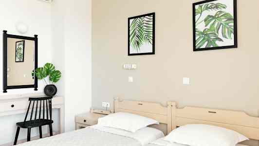 Hotelværelse med to enkeltsenge, et skrivebord og vægdekorationer med botaniske motiver. (AI-genereret tekst)