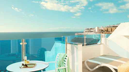 En terrasse med udsigt over havet og bygninger i baggrunden. (AI-genereret tekst)