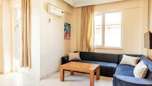 En stue med blå sofa, træbord og to vinduer. (AI-genereret tekst)