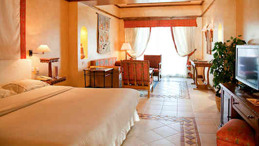 Interiør af et hotelværelse med en dobbeltseng, siddeområde og indretningsdetaljer. (AI-genereret tekst)