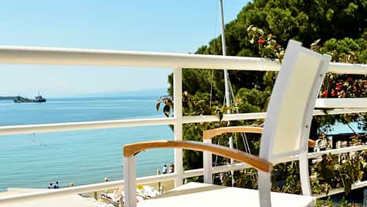 En hvid stol står på en altan med udsigt over havet. (AI-genereret tekst)