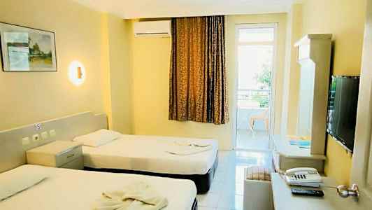 Hotelværelse med to enkeltsenge, skrivebord og tv. (AI-genereret tekst)