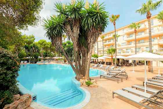 Hotelområde med pool, palmer og solvogne. (AI-genereret tekst)