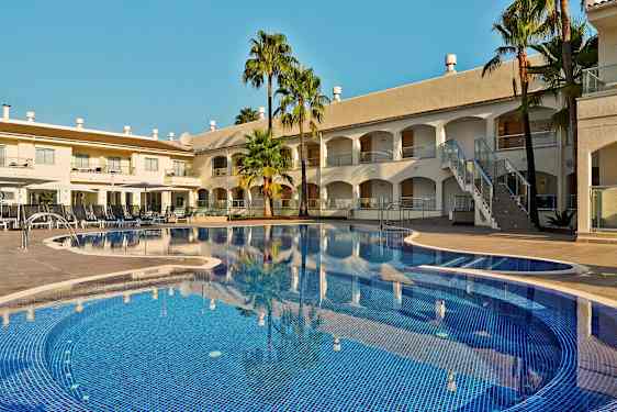 Billede af en hotelpool med liggestole og bygninger i baggrunden. (AI-genereret tekst)