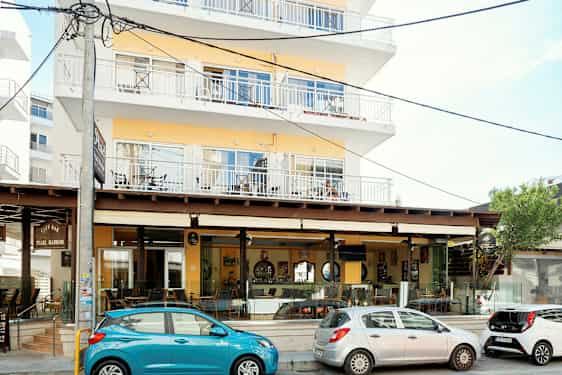 Lejlighedsbygning med café langs gaden. (AI-genereret tekst)